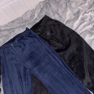 Mjukisbyxor i blått och svart 2 för 1 - Två par mjukisbyxor i supermjuk velour, ett par i mörkblått och ett par i svart. Båda har relaxed fit och resår i midjan, det svarta paret har även snörning. Perfekta för chill dagar eller när du vill vara extra bekväm.