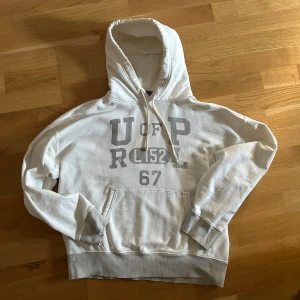 Polo Ralph Lauren Hoodie - Hej. Säljer denna exklusiva Ralph lauren hoodien som inte säljs längre. Har inte hittat några som finns kvar i storlek M utan bara mer udda storlekar där priset varierar mellan 2-3000kr. Köpt för ca 2000kr på Zalando. Har en liten fläck precis över d gråa stygnen långt ner på tröjan som du kan se på bilden men som knappt syns alls, däröver säljs för billigt. 