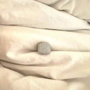 Bred silverring med glittriga stenar - Säljer en chunky silverfärgad ring med fyrkantig form och tätt satta små glittrande stenar på ovansidan. Perfekt för dig som gillar statement-smycken och vill addera lite extra bling till din stil. 400kr nypris 