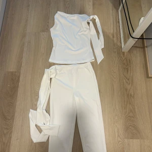 Vita vida byxor med knytband - Säljer ett par snygga shein vita byxor med vida ben