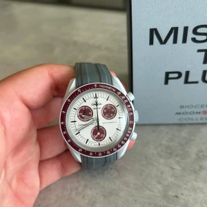 Omega x Swatch MoonSwatch Pluto - Omega Moonswatch Pluto, skicket är superfint på hela klockan förutom glaset som är repigt, det går enkelt att beställa ett nytt glas för en billig peng om man vill det, men reporna är inget man går runt och tänker på! Priset är inte helt hugget i sten.