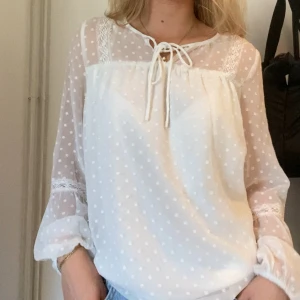 Vit blus med prickar - Supersöt vit blus som tyvärr inte kommer till användning längre! Stor nere vid ärmarna och massa fina detaljer! Använd en del men i bra skick!!