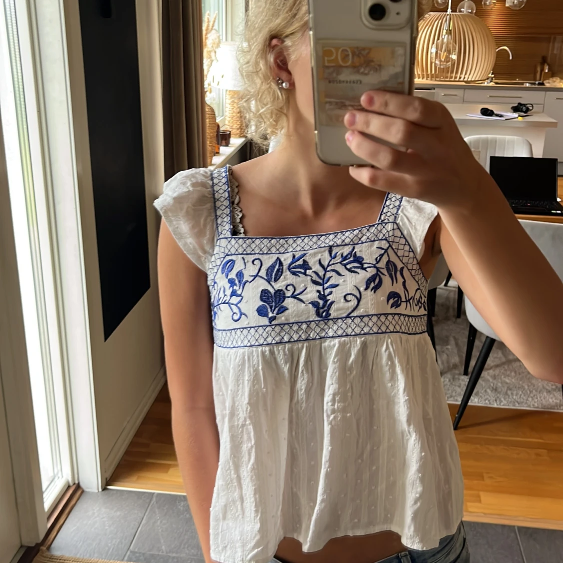 Vit blus med blå broderi och rosett