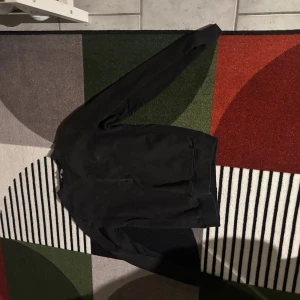 Svart sweatshirt från Valentino - En stilren svart sweatshirt från Valentino, tillverkad i Italien. Tröjan har rund halsringning, långa ärmar och ribbade muddar vid hals, ärmslut och nederkant. Perfekt för dig som gillar klassisk och enkel design med exklusiv känsla.