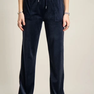 Mörkblå Juicy Couture byxor! - Mörkblå velourbyxor från Juicy Couture med raka ben och dragsko i midjan. Byxorna har bakfickor med knapp och stora fickor fram. Perfekta för en chill och trendig look. Lite slitna nere vid hälarna! Ny pris 1200kr❣️