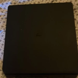 PlayStation 4 Slim - Säljer en PlayStation 4 Slim i fint skick. Konsolen är svart och kommer med tillhörande strömkabel och HDMI-kabel. Inga synliga repor eller skador på chassit. Perfekt för gaming och underhållning hemma. Fungerar utmärkt och är redo att användas direkt.