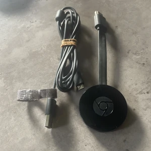 Google Chromecast 2 - Google Chromecast 2 i svart, komplett med original USB-strömkabel och HDMI-kabel som sitter på chromecasten. Enheten är i gott begagnat skick med mindre ytliga repor. Perfekt för streaming av video och musik direkt till din TV från mobilen eller datorn.
