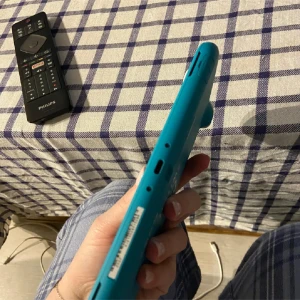 Nintendo Switch Lite Turkos (defekt)  - Nintendo Switch Lite i turkos färg, kompakt och lätt design perfekt för spel på språng. Konsolen ser ut att vara i gott skick utan synliga repor eller skador. Alla knappar och portar är intakta. Perfekt för både barn och vuxna som vill spela sina favoritspel var som helst. Obs! Defekt! Laddar inte 