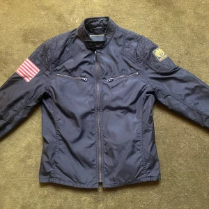 Svart vindjacka Ralph Lauren Denim & Supply - Svart vindjacka från Ralph Lauren Denim & Supply med coola detaljer som amerikansk flagga på ärmen och broderad patch. Pris kan diskuteras 😉