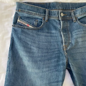 Blå jeans från Diesel Industry - Snygga blå jeans från Diesel Industry med klassisk femficksdesign och tydliga kontrastsömmar. Jeansen har en ljusblå tvätt, normal passform och detaljerad etikett bak i midjan. Perfekta för dig som gillar en tidlös denimlook.