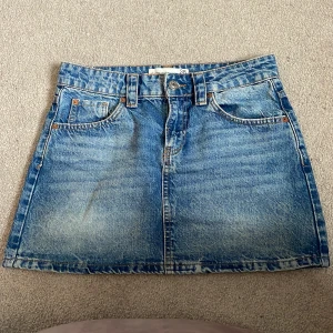 Blå jeanskjol från stradivarius  - Snygg blå jeanskjol från stradivarius. Kjolen har fickor och bälteshällor. Den är i storlek M. Har aldrig använt då det aldrig har funnits tillfälle.