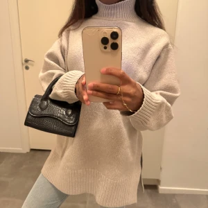 Polotröja i stickad ull - Oversized beige polotröja i stickad ull. Tröjan har höga ribbade muddar, slits i sidorna och en polokrage 🍂😍