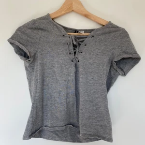 Grå crop top  - Snygg crop top med snöring, använd men säljer då den är lite för stor. Materialet är lite stretchigt