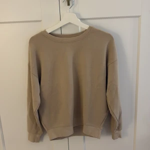 Beige sweatshirt från MSCH Copenhagen - Säljer en stilren beige sweatshirt från MSCH Copenhagen i storlek XS/S. Tröjan har en klassisk rund halsringning och långa ärmar med ribbade muddar. Perfekt för en chill och avslappnad look. Materialet är mjukt och skönt, troligtvis bomull eller polyester.
