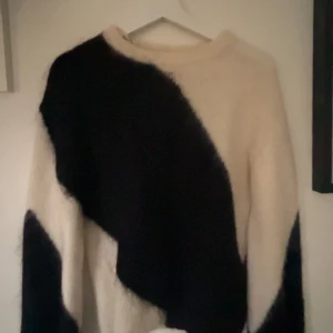 Svartvit fluffig stickad tröja - Säljer en riktigt snygg stickad svart vit tröja frön other stories i storlek xs,nästan helt oanvänd 🥰