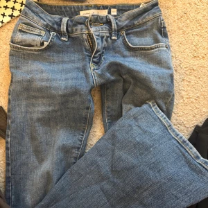 Blå jeans från Subdued, storlek 36 - Snygga blå jeans från Subdued i klassisk femficksmodell med gul kontrastsöm och cool broderad bakficka. Jeansen har dragkedja och knapp framtill, samt raka ben för en chill look. Perfekta för dig som gillar enkel och stilren denim.