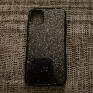 Glittrigt svart skal till iPhone 11 - Säljer ett snyggt mobilskal till iPhone 11. Köpt från H&M. Användt. Inga repor, den är i väldigt bra skick.
