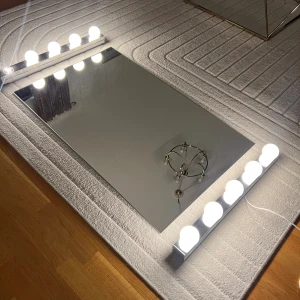 Spegel med lampor - Spegeln är 96x60cm. Lamporna är 60x5cm. Jättefint skick förutom stt en glödlampa har gått sönder men det går att fixa. Sladden till lamporna är 185cm