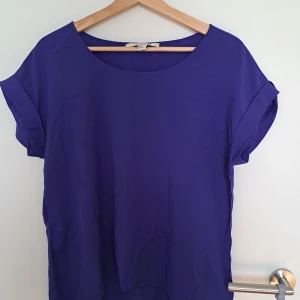 Kobaltblå  blus från Forever 21 - Snygg blå blus från Forever 21 i storlek S. Blusen har rund halsringning och korta ärmar med uppvik. Materialet känns lätt och skönt mot huden, perfekt för dig som gillar enkel och stilren design. Passar dig som vill ha en färgklick i garderoben!