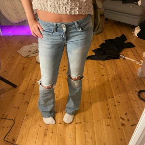 Ljusblå bootcut jeans med slitningar - Ljusblå bootcut jeans med slitningar vid knäna från Nelly. Köpta för 699kr med har trampats upp lite, därför det låga priset💖