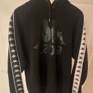 Svart Kappa hoodie - Svart hoodie från Kappa. Använd nån gång annars i väldigt bra skick! Skriv för fler bilder 