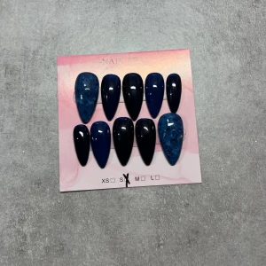 Mörkblå konstgjorda naglar S - Säljer ett set med 10  lösnaglar i storlek S. Naglarna har en snygg mörkblå färg, vissa med marmorerad effekt och andra med glansig finish. Perfekt för dig som vill ha en cool och unik look. Handgjorda 