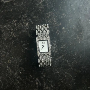 Dolce & Gabbana klocka - Säljer min Dolce & Gabbana-klocka med diamanter runt hela bandet. Den är använd bara några gånger och är en lite äldre modell, men väldigt fin och välskött. Rostfri och äkta! Skriv om ni undrar mått eller något sånt! 🥰 