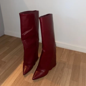 Vinröda höga boots/stövlar - Säljer mina snygga vinröda stövlar i skinn. Stövlarna är i nyskick, endast använda en gång. Storlek 39. Säljes då jag tyvärr inte får användning av dem. Nypris: 699kr. Hör gärna av er om ni har några frågor!🤍