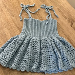 Ljusblå virkad topp ymed knyt - Superfin ljusblå virkad topp med knytbara axelband. Perfekt för varma dagar och ger en söt och trendig look.