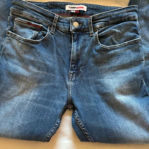 Tommy hilfiger jeans - Ett par blåa jeans från Tommy hilfiger.