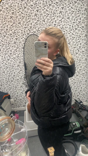 Svart pufferjacka från 157, M - Säljer en svart pufferjacka från 157 i storlek M. Jackan är quiltad med dragkedja framtill och har en hög krage samt huva. Den är i syntetmaterial och har en klassisk, boxig passform som är riktigt chill och passar perfekt till kalla dagar. Säljer då den har blivit för stor för mig , använd kanske 2 gånger 💕