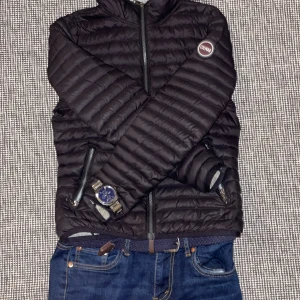 Svart pufferjacka från Colmar !pris kan diskuteras! - Säljer en svart pufferjacka från Colmar med horisontella quiltade paneler och två dragkedjeförsedda fickor framtill. Jackan har lång ärm, hel dragkedja och en stilren look som passar perfekt för kyliga daga Om du vill ha mycket självförtroende och vara grish så köp jackan 