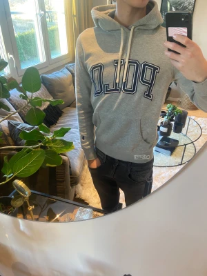 Grå hoodie från Ralph Lauren - Snygg grå hoodie från Ralph Lauren med stor logga på bröstet. Tröjan har huva med vita snören, känguruficka och ribbade muddar. Perfekt för chill dagar och enkel att matcha med jeans eller joggers. Tröjan är i toppen skick utan defekter, kontakta för fler frågor eller bilder 🙌🏻