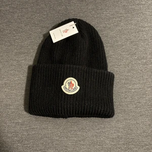 Svart ribbstickad mössa från Moncler - Säljer ett svart moncler mössa som är helt nya. Kan gå ner i pris vid snabb affär!