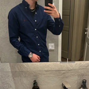 Mörkblå skjorta från Ralph Lauren - Säljer denna skit snygga skjortan från Ralph Lauren. Säljer den eftersom jag inte har användning av den. Storlek: M. Cond: 9/10, inga defekter. Nypris: 1499kr. Säljer den för 799kr, priset kan diskuteras!