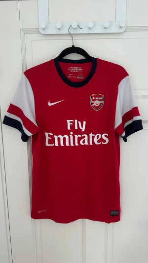Äkta arsenal 12/14 fotbollströja S - Arsenals hemmatröja från säsongen 12/14 i storlek s, bra skick lite slitningar på armen 