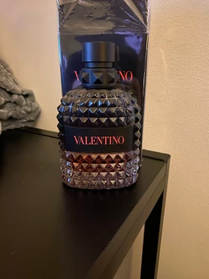 Valentino Born In Roma Coral Fantasy - Parfymflaska från Valentino, Born In Roma Coral Fantasy. Flaskan är mörk med nitar och har en lyxig, robust design i glas med svart och röd etikett. Kommer med originalförpackning. Perfekt för dig som gillar exklusiva dofter och snygg design.  70ml kvar 