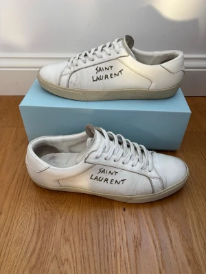 Vita Saint Laurent sneakers i skinn - Hej 👋 skorna har använts en del men har defekter förutom att de är creasade de är köpte från trendsellers. Frakt inom 24 h‼️ÄKTA 