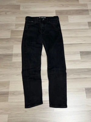 Svarta raka jeans från Karve - Snygga svarta jeans från Karve med klassisk femficksdesign och raka ben. Jeansen har en enkel look utan slitningar eller dekorationer, vilket gör dem lätta att matcha med olika stilar. Tillverkade i mjukt denimtyg för skön känsla.