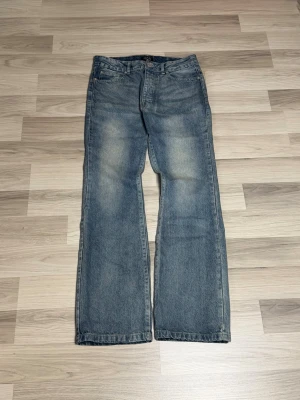 Flared jeans från boohoo - Blåa flared jeans från boohoo och fem fickor. Passar bra på mig som är 181cm. Jeansen har en tidlös look med ljus tvätt och knappgylf. Perfekta för dig som gillar en avslappnad och autentisk denimstil.