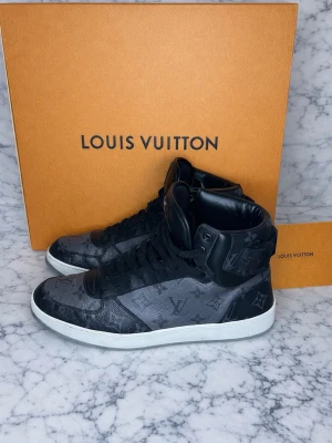 Louis Vuitton Rivoli high-top sneakers - Storlek: 42                                                                                                                      Skicket: Bra men finns några sprickor i lädret skriv privat så fixar jag bilder.                                                            Allt og ingår: |Kvitto|Dustbag|Låda|Påse om man möts upp| Skorna är köpte av mig på Louis Vuitton vid Birger Jarlsgatan för 8400kr och kvittot finns.                                                 Kontakta för mer information ✅