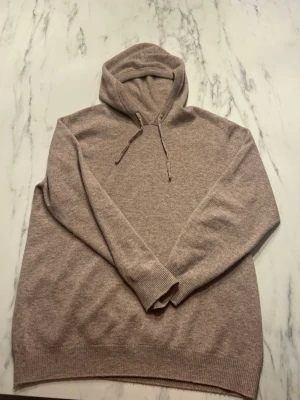 Kashmir hoodie - En beige Kashmir hoodie i mycket bra skick använd få tal gånger. En väldigt skön Kashmir hoodie för alla typer av outfiter. Pris kan diskuteras vid snabb affär. Hör av er vid fler frågor.