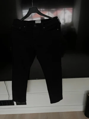 Svarta skinny jeans från Jaclyn - Svarta jeans från Jaclyn med klassisk femficksdesign och classisc passform. Jeansen har normal midja och är tillverkade i ett stretchigt jeanstyg som sitter snyggt på benen. Perfekta för en stilren och enkel look. Lite lite uppsydda 