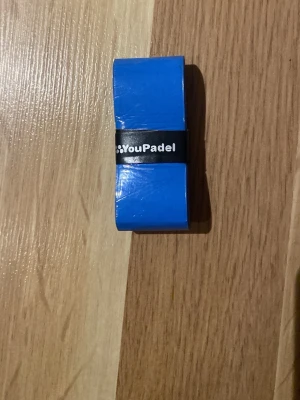 Blått padelgrepp från GoYouPadel - Säljer ett blått padelgrepp från GoYouPadel. Greppet är tillverkat i syntetmaterial och har en slät yta. Perfekt för att få bättre grepp på ditt padelracket. Enkel att linda på och sitter bra tack vare den medföljande svarta remsan.