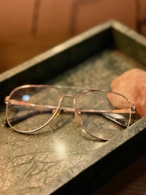 Glasögon Michael Kors - Snygga aviator-solglasögon från Michael Kors med tunn guldfärgad båge. Klassisk pilotform som ger en tidlös vibe och passar till de flesta outfits. Lätta och bekväma att bära. Glasen har styrka, minns ej vilken men lär ändå bytas ut av köparen. Köpta 2017 , synliga tecken på användning dock legat på hyllan många år. 