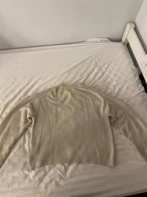 Beige stickad tröja från H&M XS - Mysig beige stickad tröja från H&M i storlek XS. Tröjan har rund halsringning, ribbade muddar och lång ärm. Perfekt till vardagen till ett par jeans tillexempel.