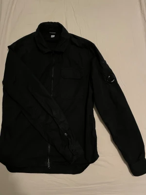 CP Company Overshirt - Säljer denna riktigt snygga overshirten, den är väldigt sparsamt använd och det finns inga skador eller slitage. Givetvis så är den äkta, nypris ~4000kr🙌