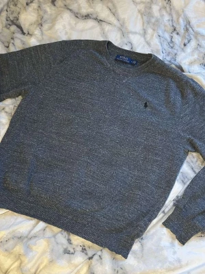 Mörkgrå stickad tröja från Polo Ralph Lauren - Mörkgrå stickad tröja från Polo Ralph Lauren med svart logga på bröstet. Perfekt för varje dag och enkel att matcha. Mycket bra skick utan defekter. Postar inom 24h!📦köp mer än ett plagg för 10% rabatt🤝