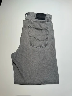 Gråa jeans från Jack & Jones stl 29, 32 - Snygga grå jeans från Jack & Jones. Raka ben med passform baggy. Modell Baggy Alex 