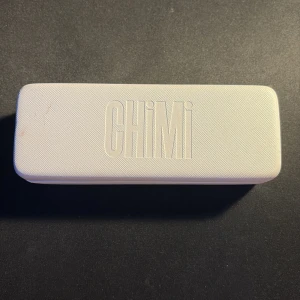 Chimi 02 transparenta runda solglasögon - Säljer ett par stilrena solglasögon från Chimi med transparent båge och runda svarta glas. Medföljer gör ett vitt hårt fodral med CHIMI-logga och en vit tygpåse. Perfekta för dig som vill ha en modern och clean look.